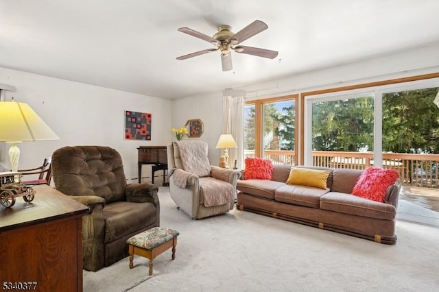 living area featuring a ceiling fan, light carpet, and baseboard heating