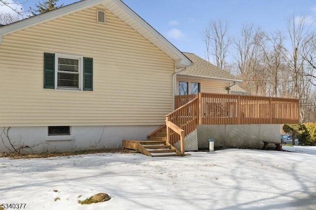 snow covered property with stairs and a wooden deck