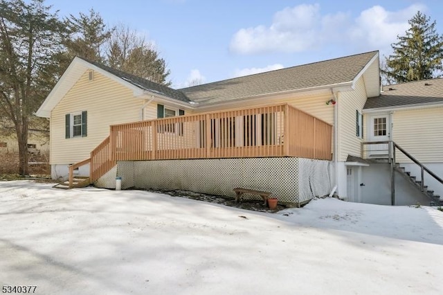 snow covered property featuring a deck and stairway