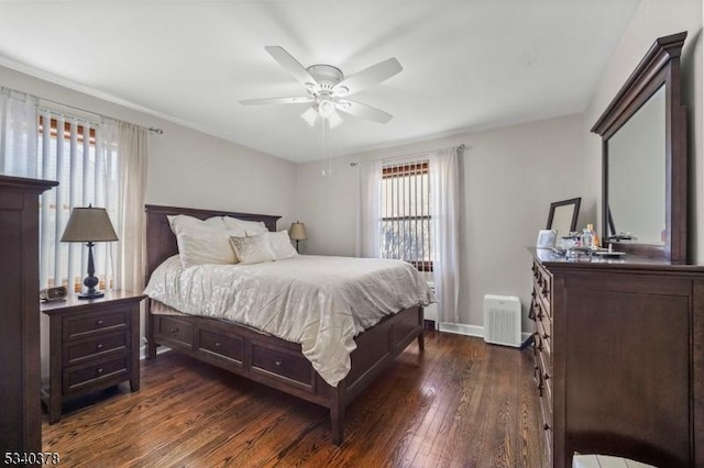 bedroom with dark wood-type flooring, ceiling fan, and baseboards