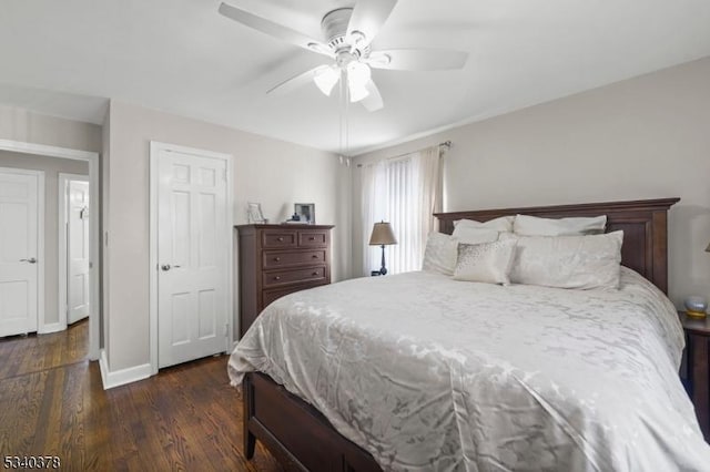 bedroom with ceiling fan, dark wood-type flooring, and baseboards