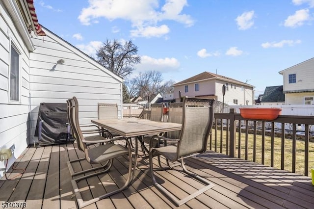 wooden terrace featuring outdoor dining area and a grill