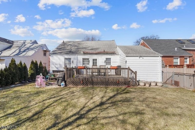 back of property with a yard, fence, and a wooden deck