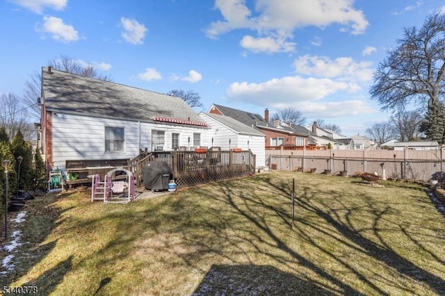 rear view of property with a deck, a yard, and a fenced backyard