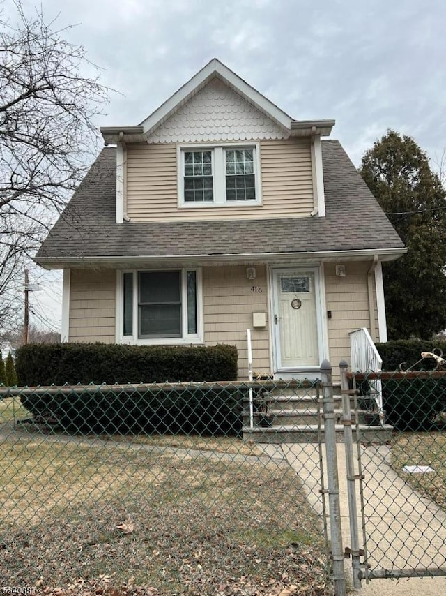 bungalow-style home featuring a shingled roof, a gate, and a fenced front yard