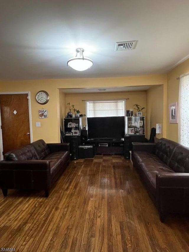 living area featuring visible vents and wood finished floors