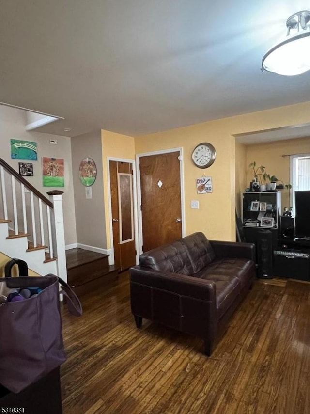 living room with stairs, baseboards, and wood finished floors