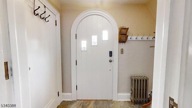 doorway featuring radiator heating unit and arched walkways