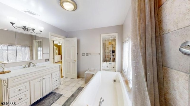 bathroom featuring a whirlpool tub, vanity, tile patterned flooring, and visible vents