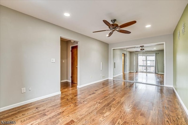 spare room with recessed lighting, wood finished floors, and baseboards