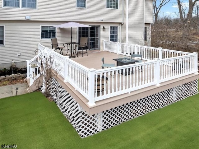wooden terrace with a lawn and outdoor dining space