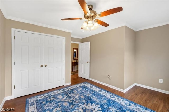 bedroom featuring ceiling fan, wood finished floors, baseboards, ornamental molding, and a closet