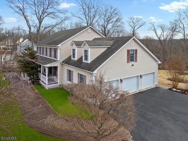 view of side of home with a garage and aphalt driveway