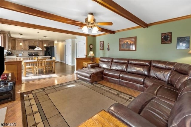 living room with crown molding, beamed ceiling, and a ceiling fan