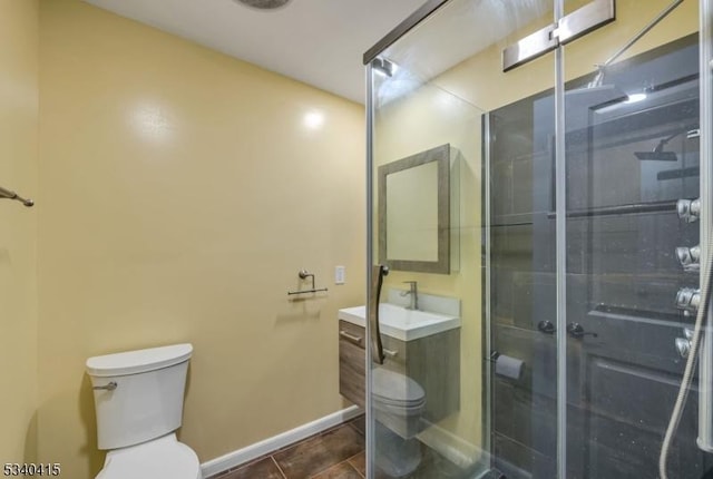 bathroom with baseboards, toilet, tile patterned floors, vanity, and a shower stall