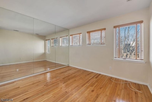 unfurnished bedroom with wood-type flooring and baseboards