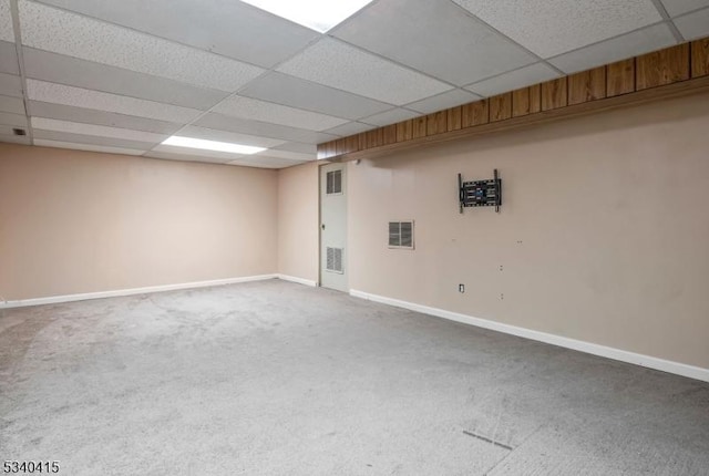 finished basement with a paneled ceiling, baseboards, visible vents, and carpet flooring