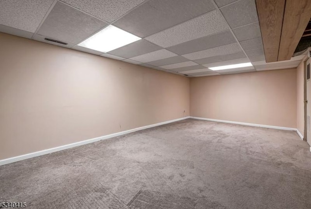 carpeted spare room featuring a drop ceiling, visible vents, and baseboards