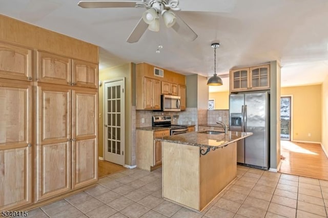 kitchen featuring visible vents, decorative backsplash, an island with sink, appliances with stainless steel finishes, and a sink