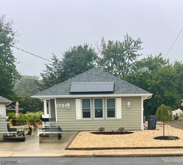 exterior space with roof with shingles and roof mounted solar panels