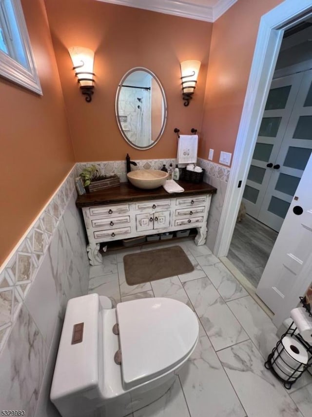 bathroom featuring a wainscoted wall, marble finish floor, vanity, and crown molding