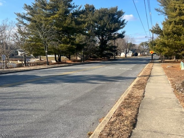 view of road featuring curbs, traffic signs, and sidewalks