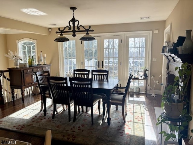 dining area featuring plenty of natural light, visible vents, and dark wood-type flooring