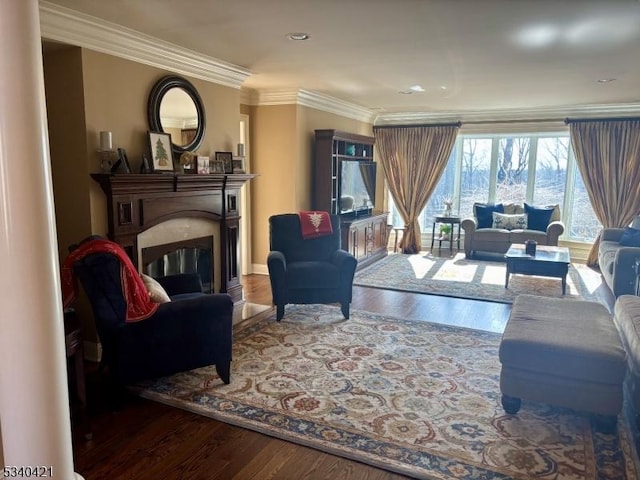 living room featuring a glass covered fireplace, crown molding, and wood finished floors