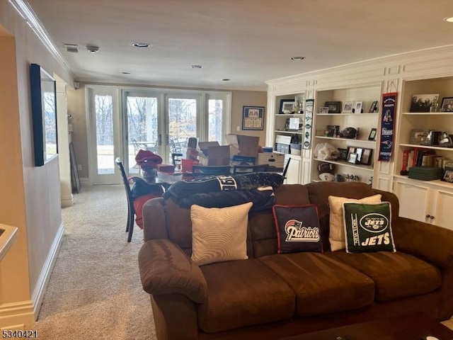 living area with light carpet, built in features, baseboards, french doors, and ornamental molding