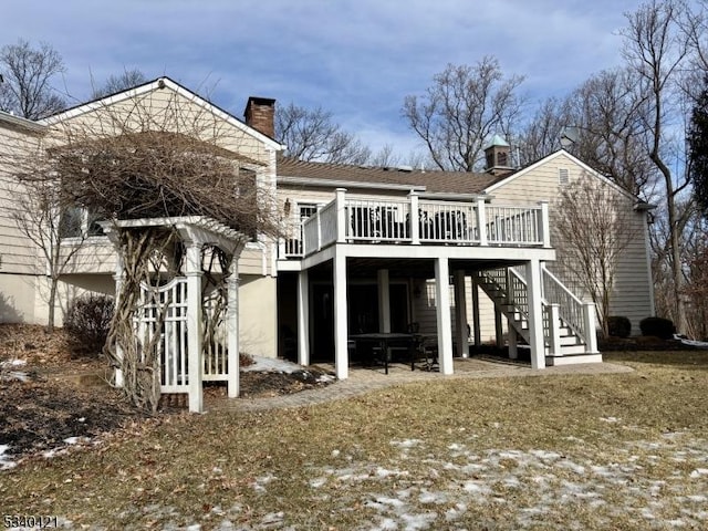 back of property featuring stairs, a chimney, and a wooden deck