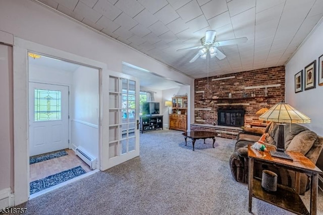 carpeted living area featuring a baseboard radiator, plenty of natural light, a fireplace, and a baseboard heating unit