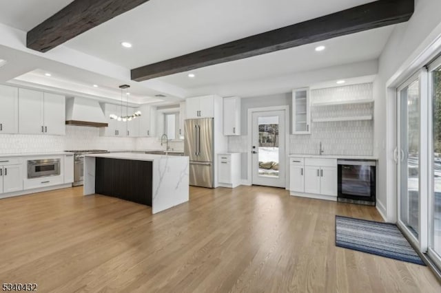 kitchen featuring premium appliances, wine cooler, custom exhaust hood, open shelves, and white cabinets