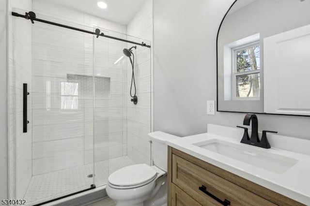 full bathroom with a shower stall, toilet, and vanity