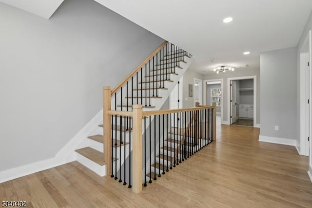 stairway featuring recessed lighting, wood finished floors, and baseboards