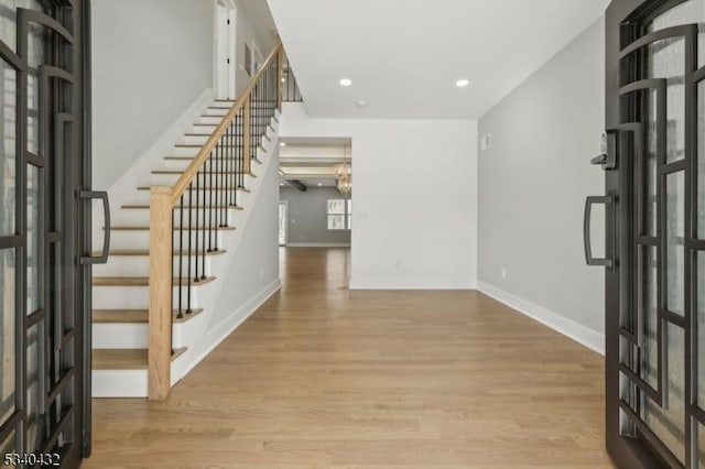 foyer entrance with stairs, recessed lighting, baseboards, and wood finished floors