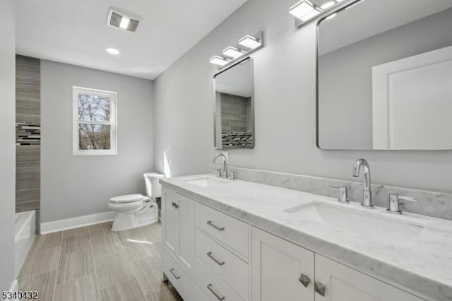 bathroom with toilet, a sink, visible vents, and baseboards