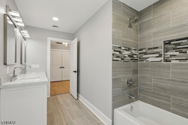 full bath featuring double vanity, visible vents, baseboards, a sink, and shower / bathing tub combination