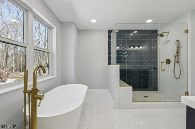 bathroom featuring recessed lighting, baseboards, marble finish floor, a soaking tub, and a stall shower