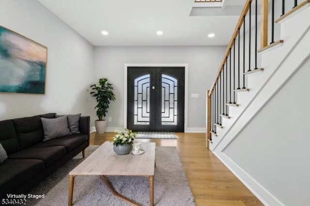 living room featuring recessed lighting, french doors, stairway, and light wood finished floors