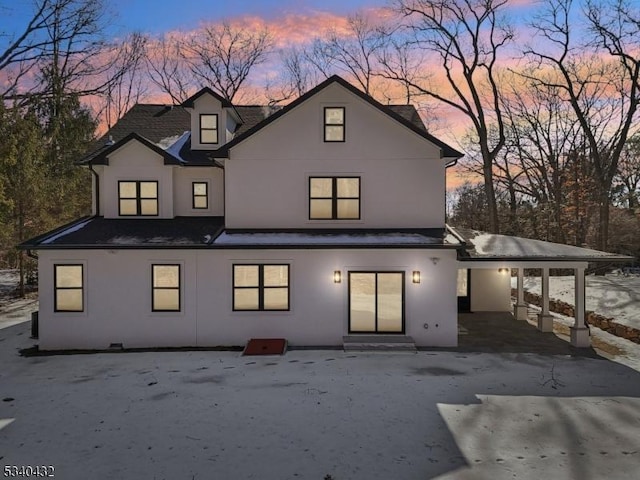 rear view of property featuring entry steps, a carport, and stucco siding