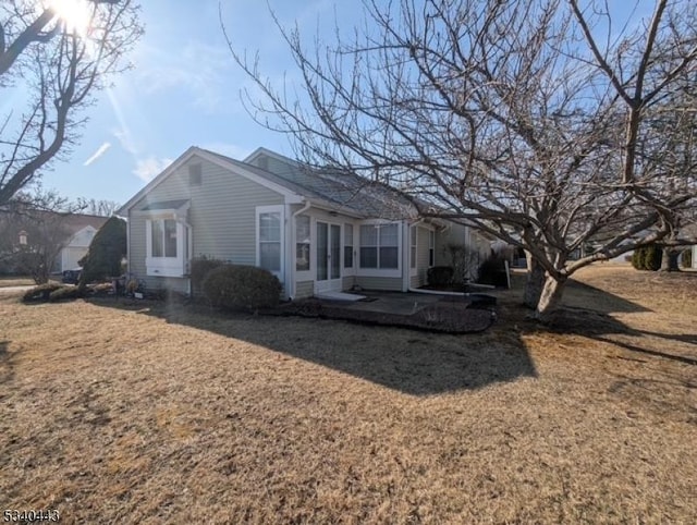 rear view of property featuring a patio and a yard