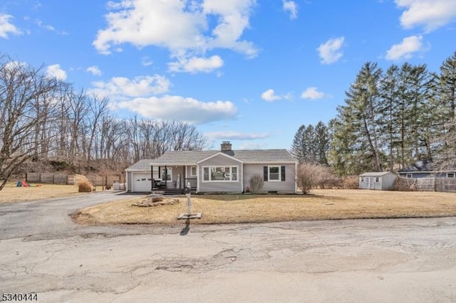 view of front of house featuring a garage, fence, driveway, a front lawn, and a chimney