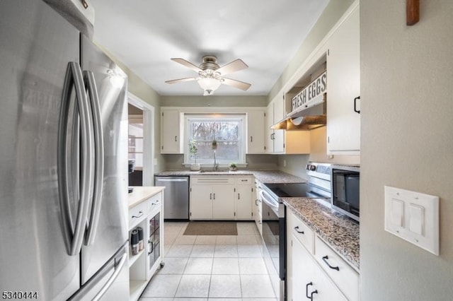 kitchen featuring light tile patterned floors, appliances with stainless steel finishes, white cabinetry, a sink, and under cabinet range hood