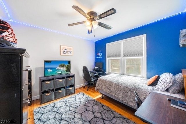 bedroom featuring ceiling fan, wood finished floors, and baseboards