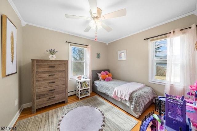 bedroom featuring crown molding, baseboard heating, and wood finished floors