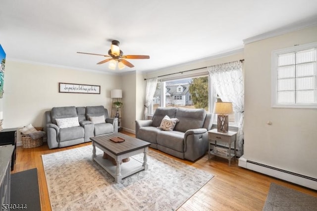 living area featuring a baseboard radiator, ornamental molding, and wood finished floors