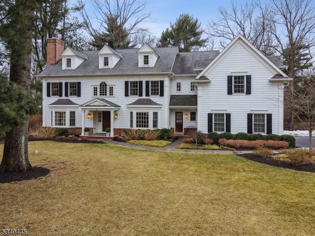 view of front of property featuring a chimney and a front lawn