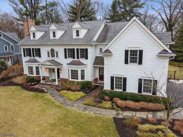 view of front facade with a front lawn and a chimney