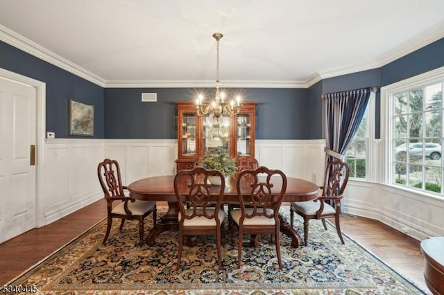 dining room with a chandelier, visible vents, a healthy amount of sunlight, and wood finished floors