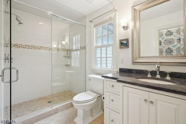 full bath with tile patterned floors, a shower stall, toilet, and vanity